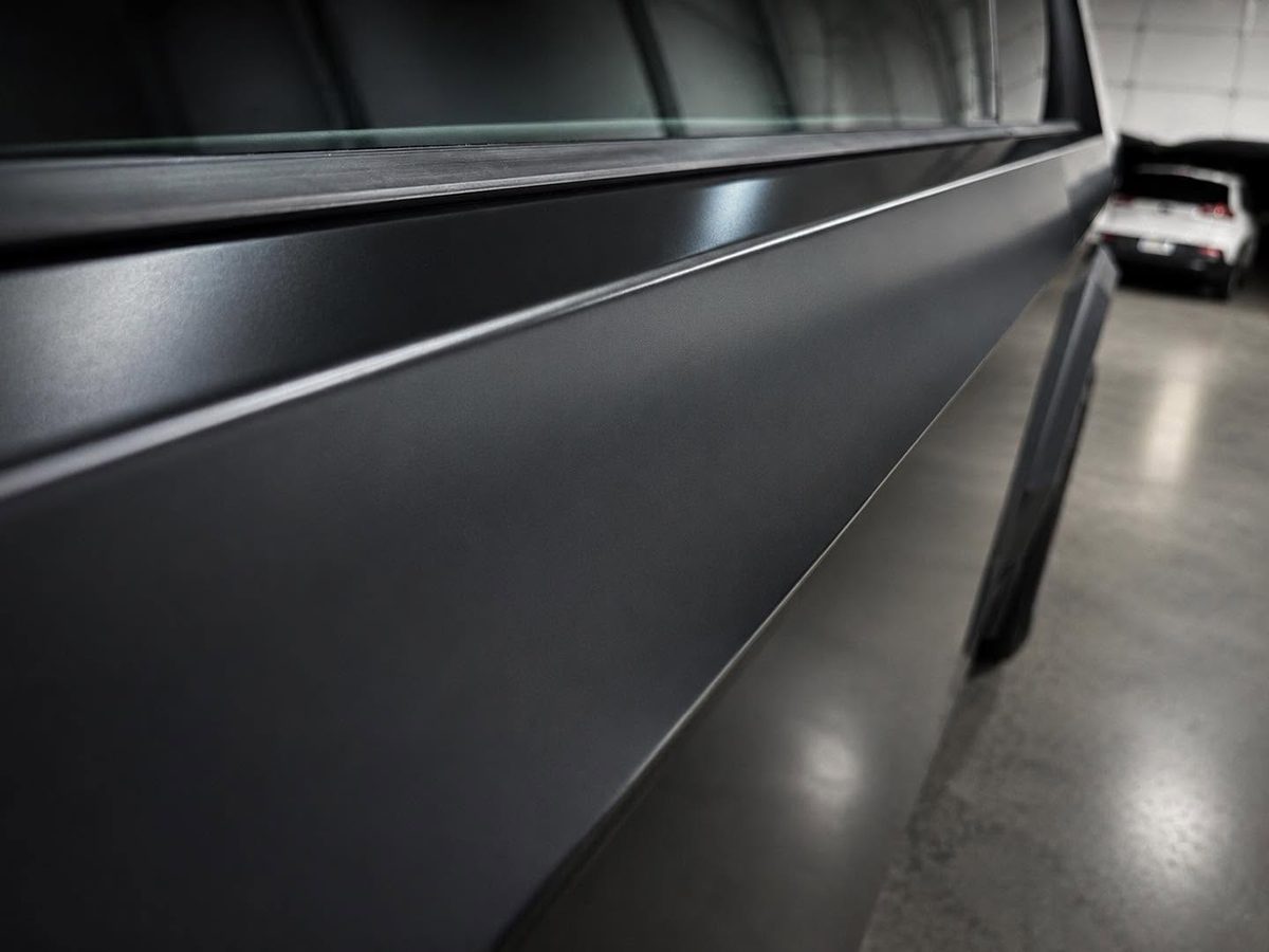 Close detail of the satin black film along the body crease